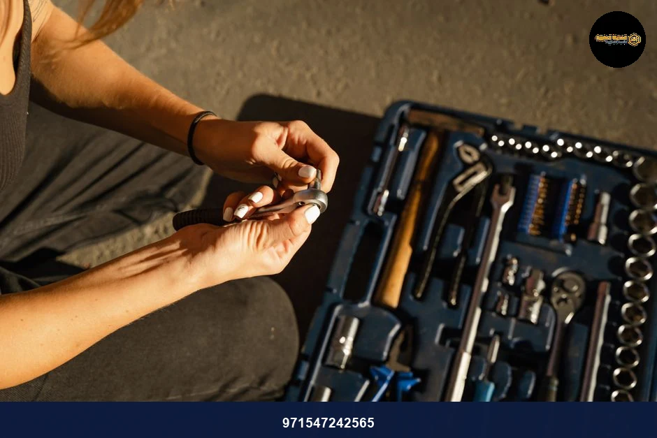 Close-up of hands using tools from a toolset in a well-lit workshop setting.