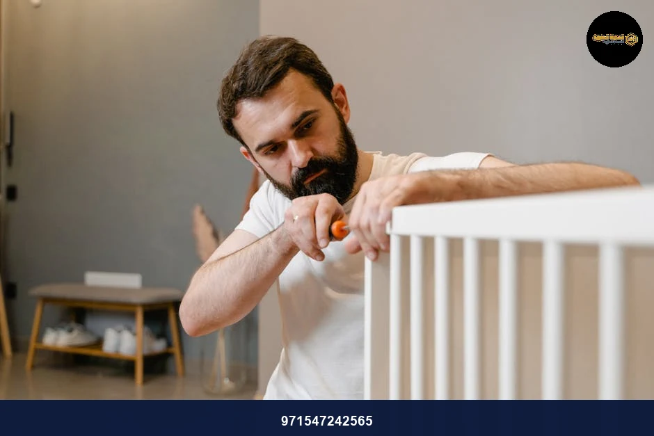 A father attentively assembles a white baby crib in a cozy modern room.