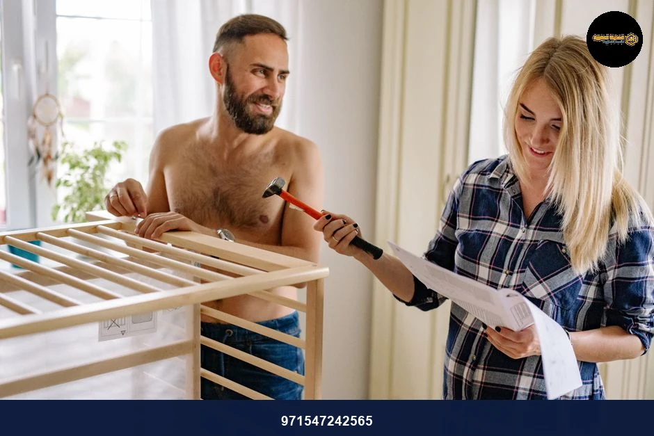 A man and woman assembling a crib together with tools and instructions.