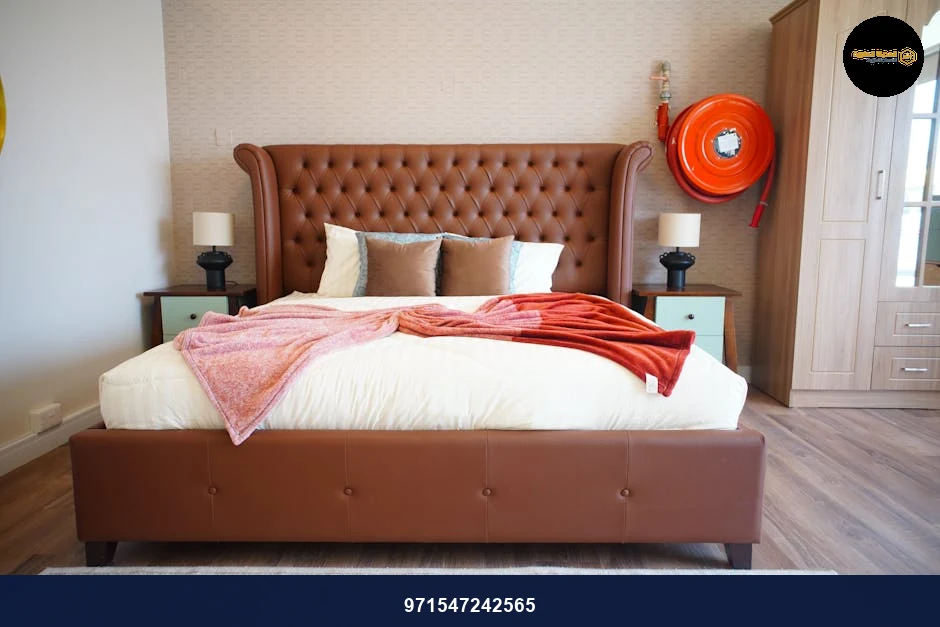 A cozy, elegant bedroom featuring a tufted brown bed and soft lighting.