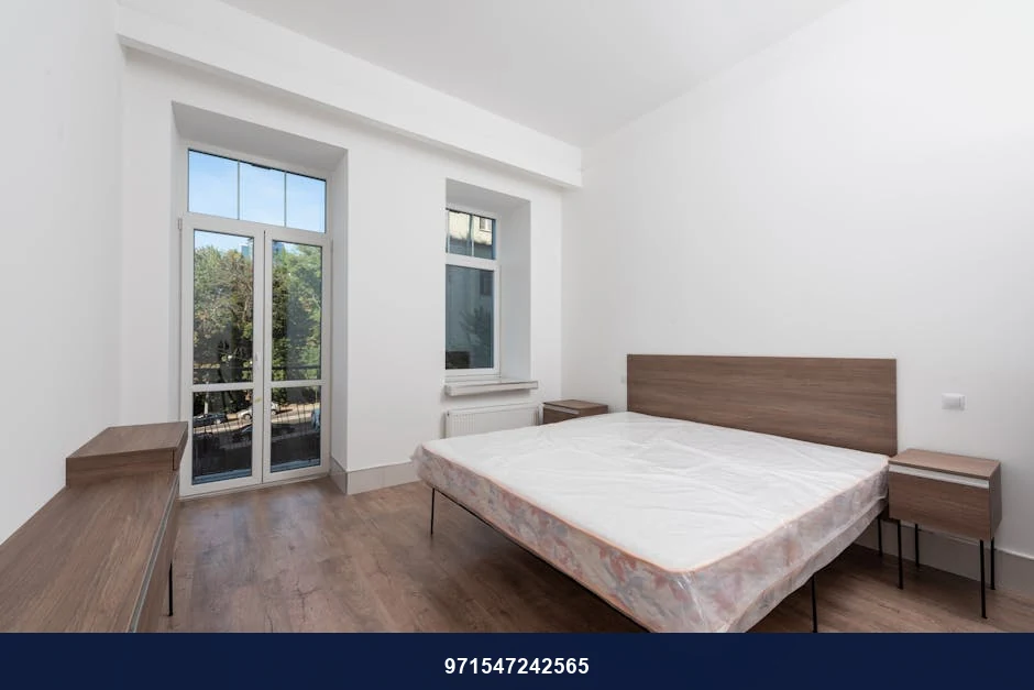 Bright and minimalist bedroom featuring a modern design with natural light from window. Bright and minimalist bedroom featuring a modern design with natural light from window.