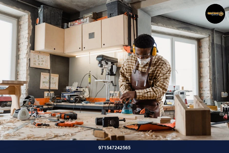 A skilled craftsman working with tools in a well-equipped woodworking workshop.
