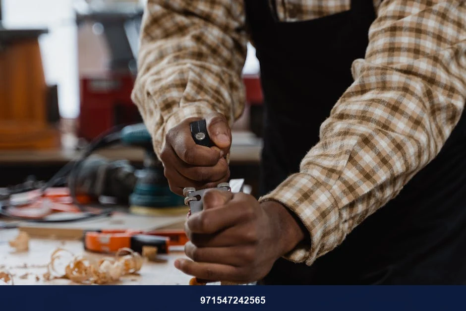 A craftsman skillfully using a hand plane on wood in a woodworking workshop.