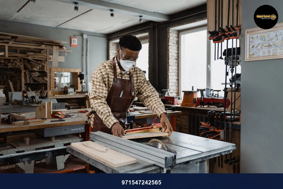 Professional woodworker using saw in well-equipped workshop, focusing on creation and craftsmanship.