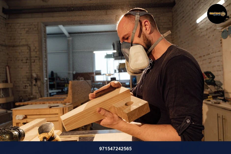 Skilled carpenter wearing mask, shaping wood with tools in a workshop environment.