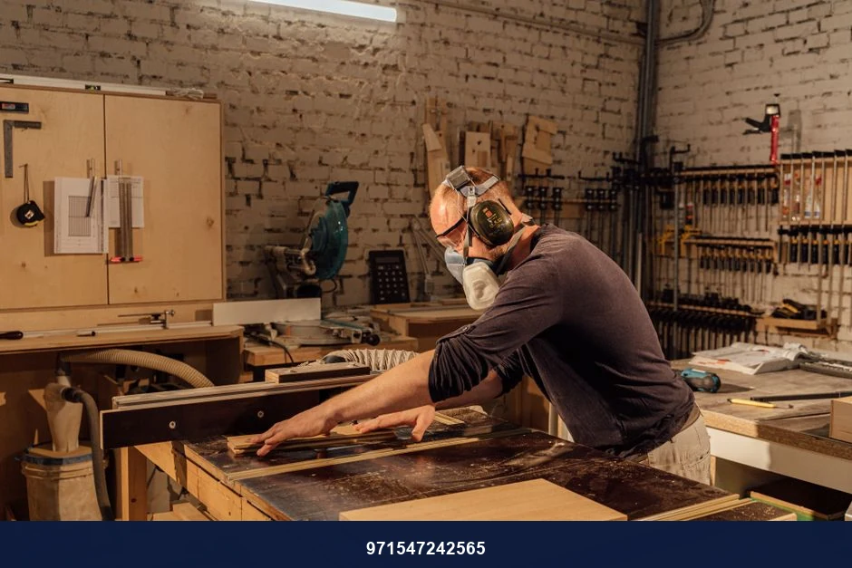 Experienced woodworker using a table saw in a well-equipped woodworking shop.
