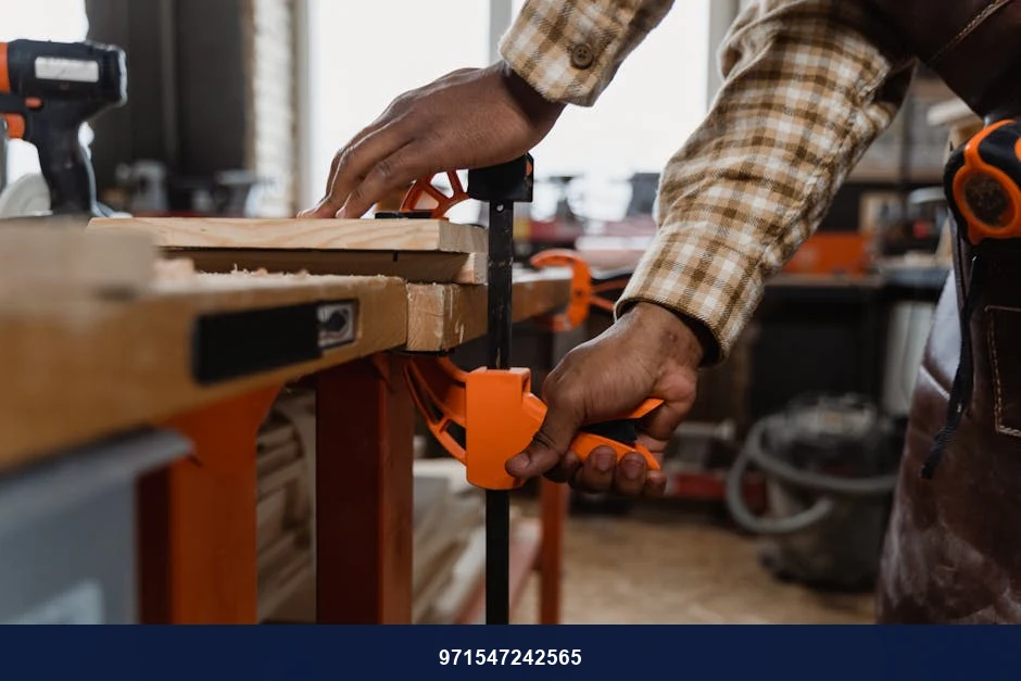 A craftsman skillfully clamps wood in a workshop filled with tools, showcasing fine woodworking techniques.
