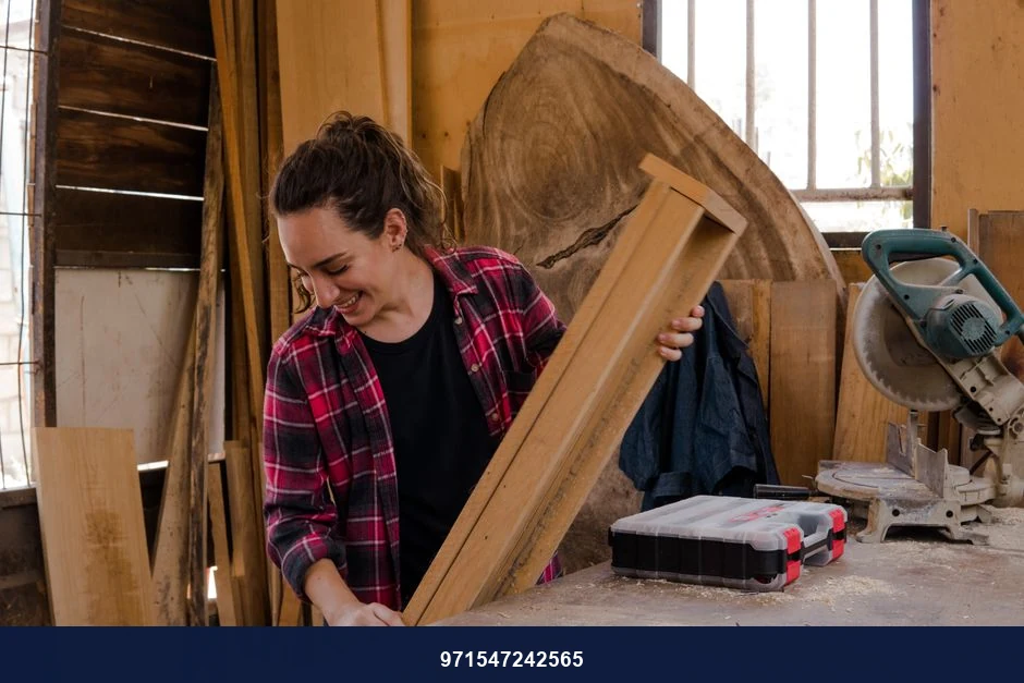 A woman carpenter handling wood in a workshop, showcasing woodworking skills and craftsmanship.