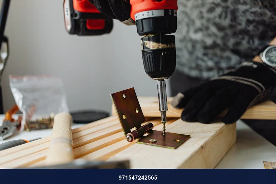 Close-up of a skilled carpenter using a power drill on wood in a workshop.