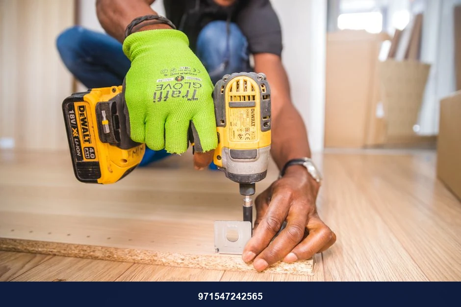 Man using a power drill for home improvement on a wooden floor with precision.