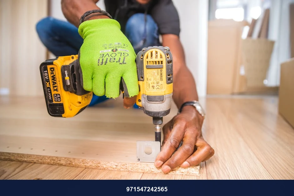 Man using a power drill for home improvement on a wooden floor with precision.