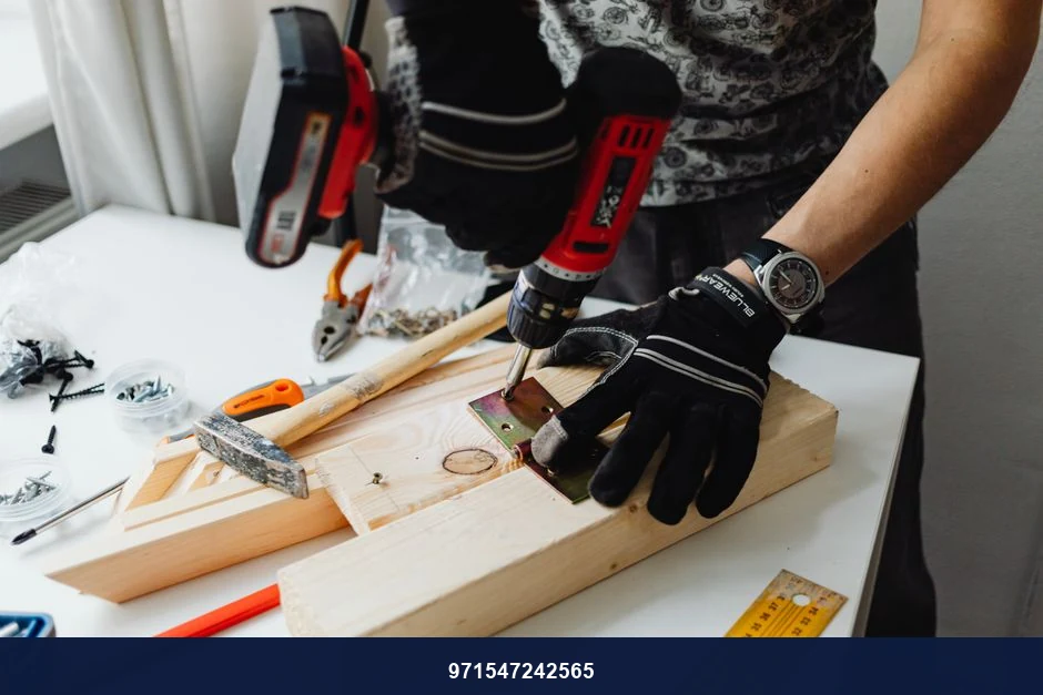 A craftsman uses a power drill on wood, showcasing carpentry tools and skills.
