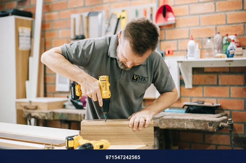 A carpenter working with a drill in a well-equipped workshop.