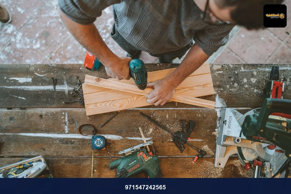 Craftsman busy drilling wooden planks in a carpentry workshop with various tools around. Craftsman busy drilling wooden planks in a carpentry workshop with various tools around.