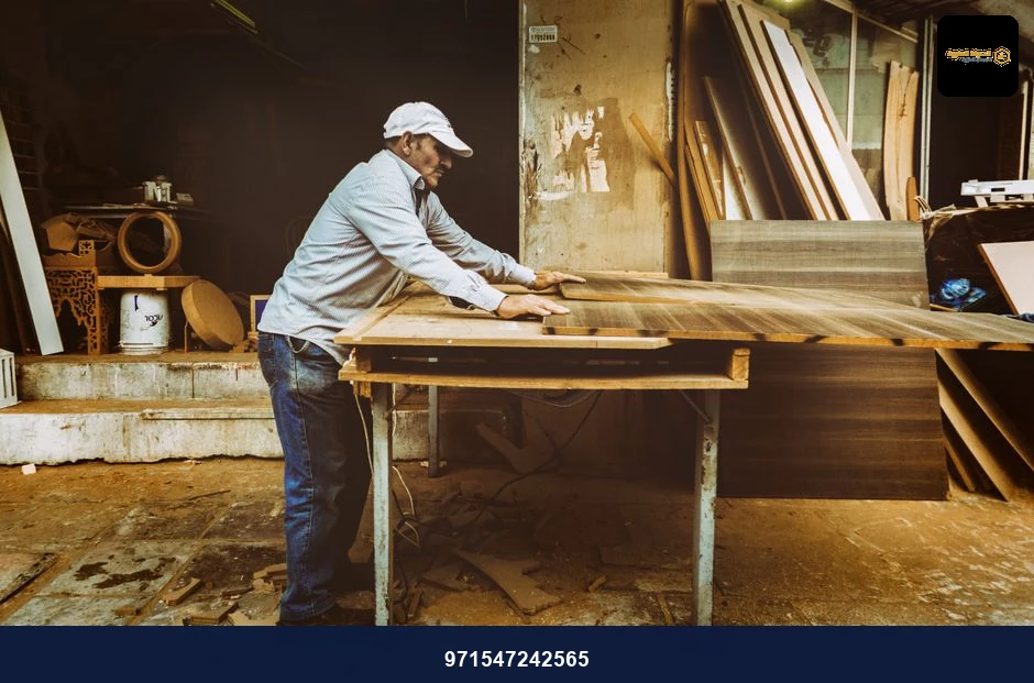 Carpenter focuses on woodworking project inside a busy workshop, surrounded by materials. Carpenter focuses on woodworking project inside a busy workshop, surrounded by materials.