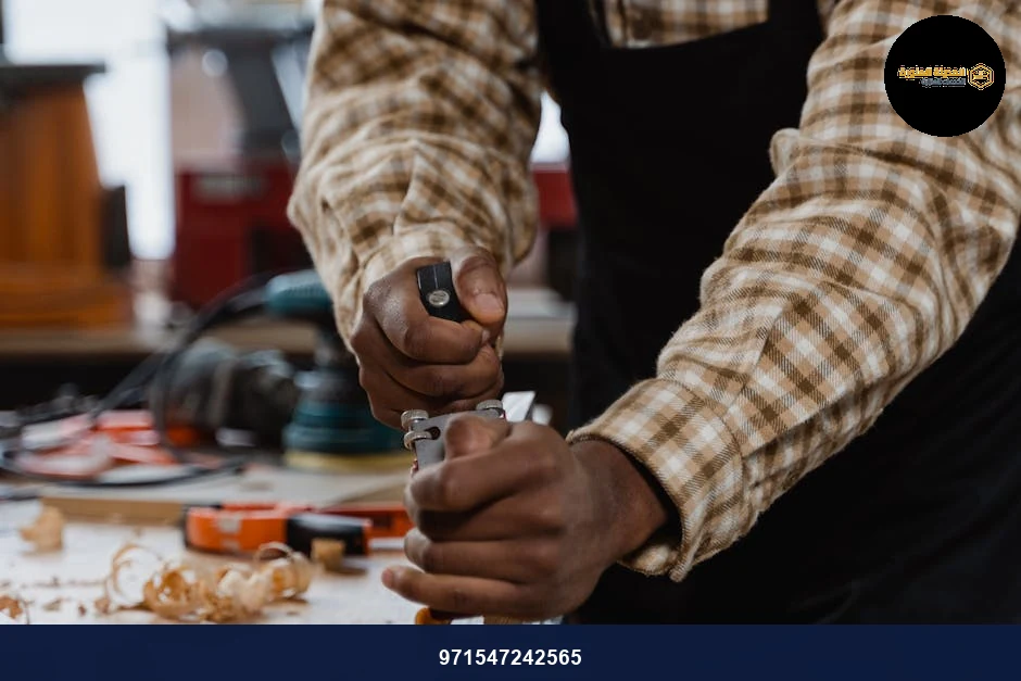 A craftsman skillfully using a hand plane on wood in a woodworking workshop.