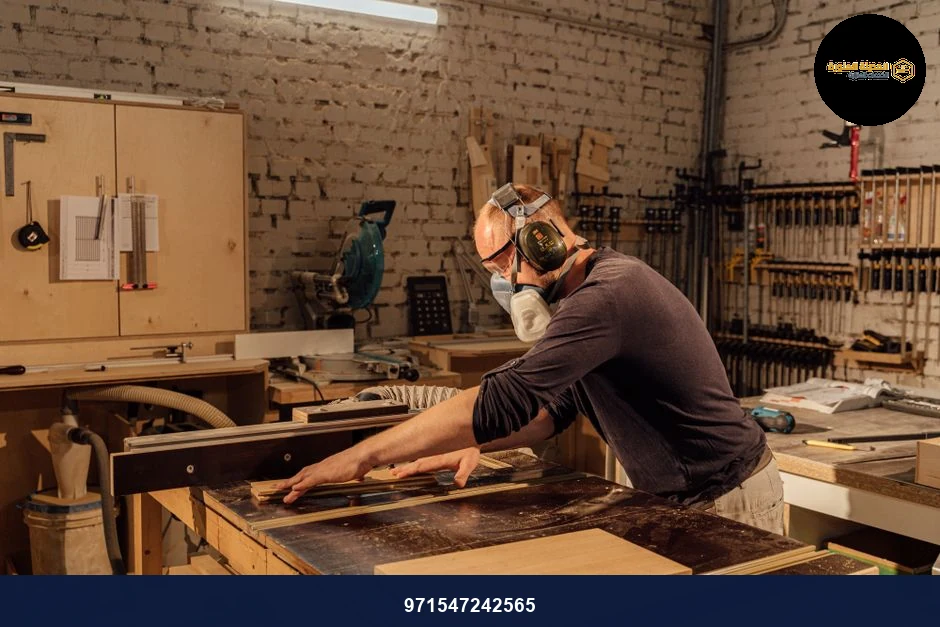 Experienced woodworker using a table saw in a well-equipped woodworking shop.