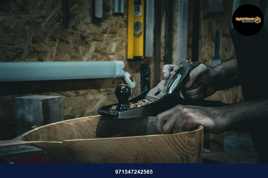 Close-up of craftsman smoothing wood with a hand plane in a workshop, emphasizing skilled carpentry.