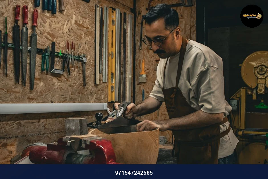 Carpenter using hand tools to shape wood in a workshop environment.