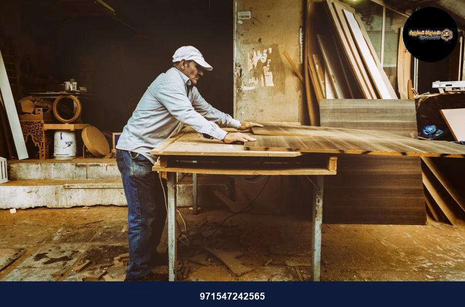 Carpenter focuses on woodworking project inside a busy workshop, surrounded by materials. Carpenter focuses on woodworking project inside a busy workshop, surrounded by materials.
