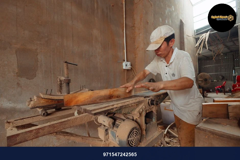 A carpenter in a dusty workshop precisely cuts wood using an industrial saw. A carpenter in a dusty workshop precisely cuts wood using an industrial saw.