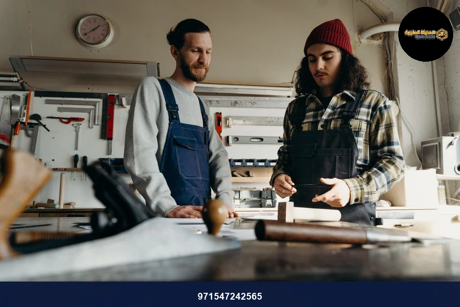 Two male carpenters working together in a well-equipped workshop. Two male carpenters working together in a well-equipped workshop.