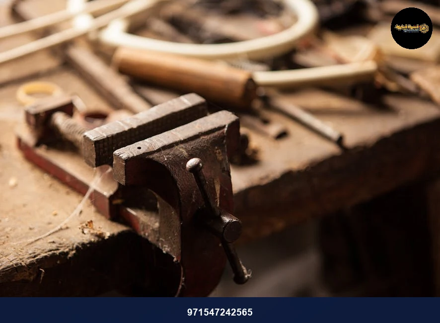 A detailed view of a workshop table with tools highlighting a metal clamp and wood textures.