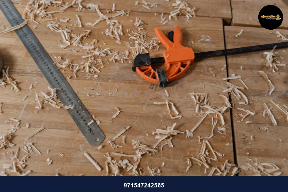 Close-up of woodworking tools on a wooden workbench with scattered sawdust.