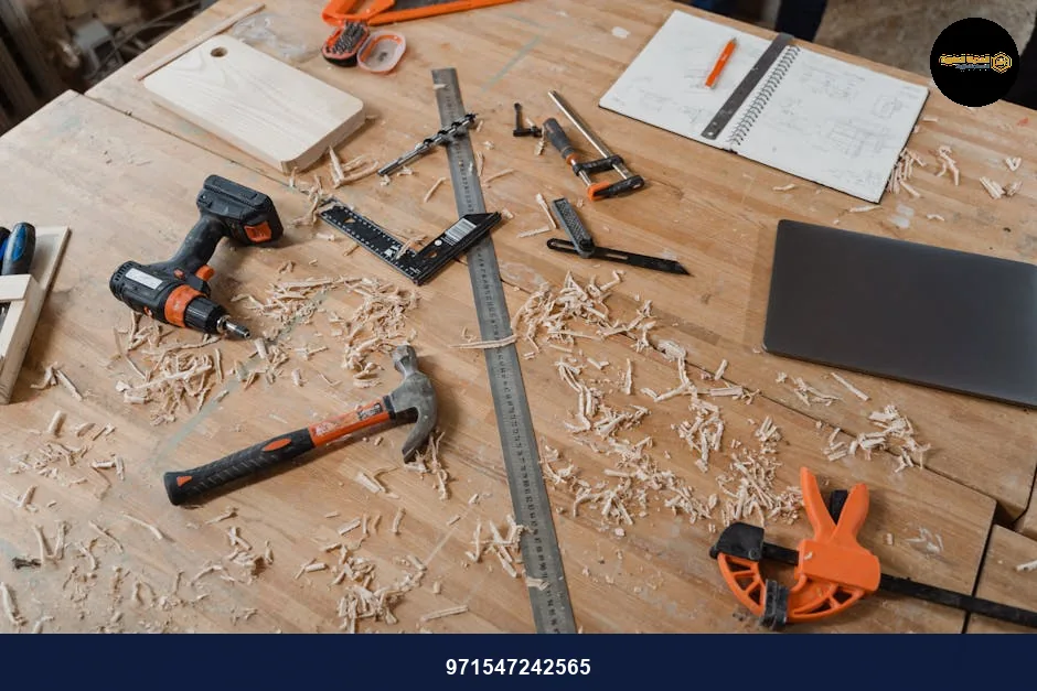 A workbench with various woodworking tools alongside sketches and wood shavings, indicating an active project.