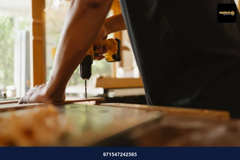 Crop anonymous male carpenter making hole on wooden plank with drill during work in studio on sunny day Crop anonymous male carpenter making hole on wooden plank with drill during work in studio on sunny day