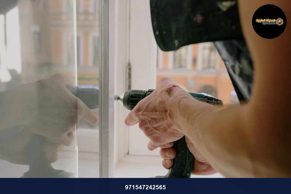 Unrecognizable professional male worker assembling white window with cordless screwdriver with drill near windowsill with reflection on glass during repair works in apartment. Unrecognizable professional male worker assembling white window with cordless screwdriver with drill near windowsill with reflection on glass during repair works in apartment.
