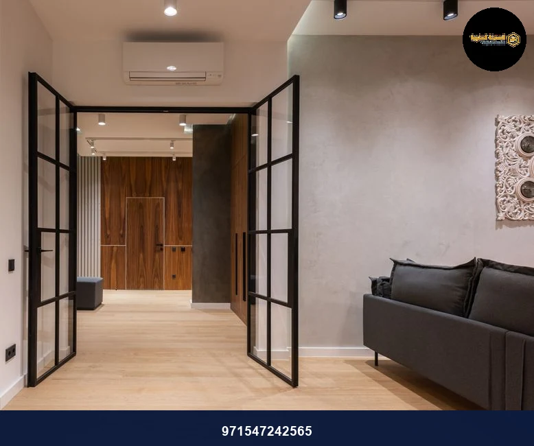 Interior of modern bright house with open doors to hallway near sofa with pillows Interior of modern bright house with open doors to hallway near sofa with pillows