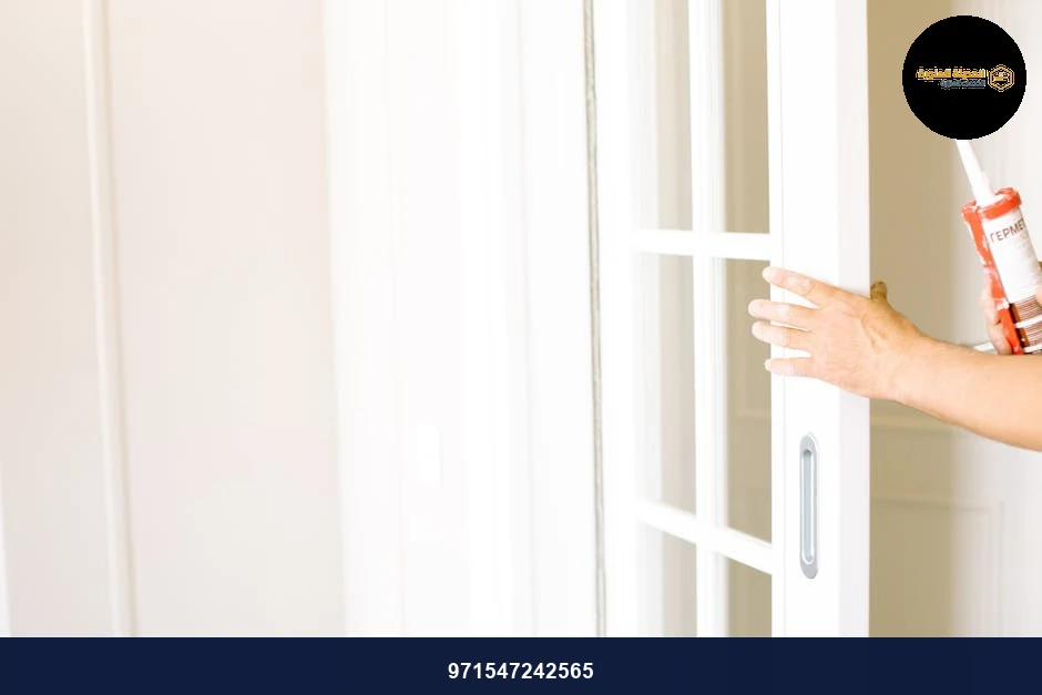 A person applies sealant to a sliding glass door, enhancing home aesthetics. A person applies sealant to a sliding glass door, enhancing home aesthetics.
