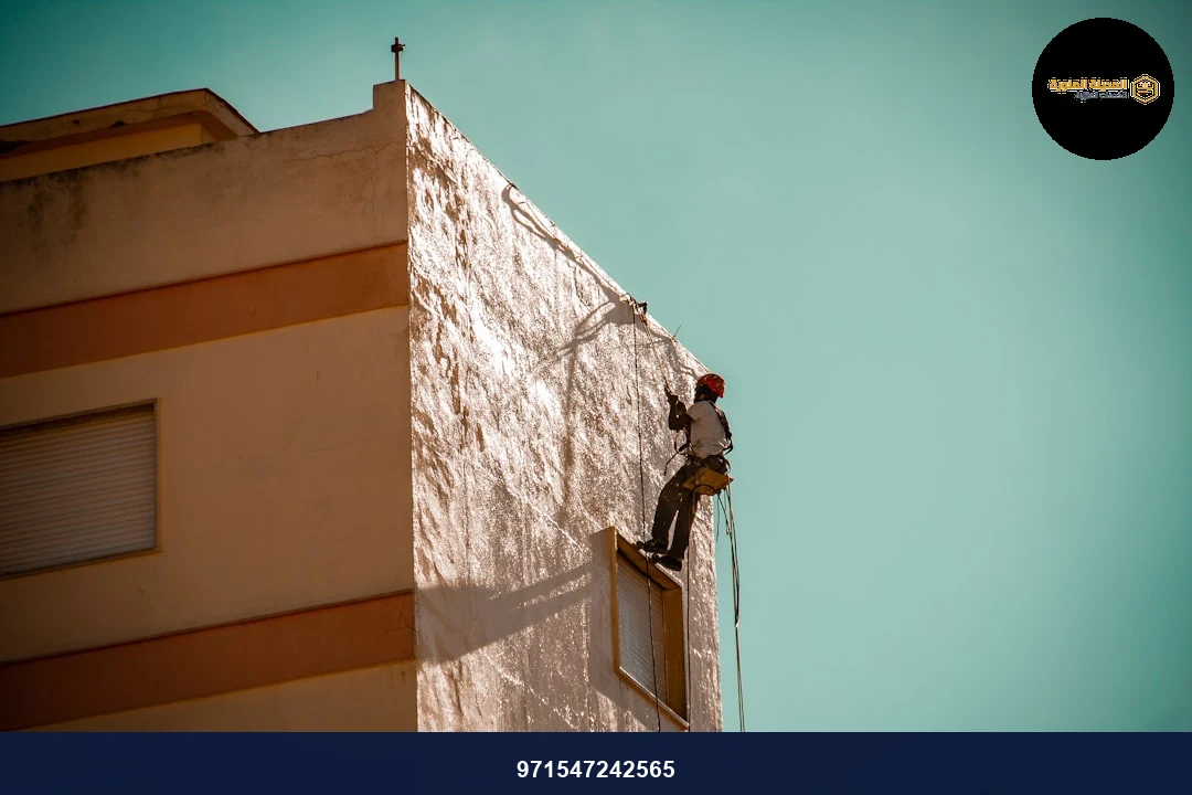 a man on a ladder working on the side of a building