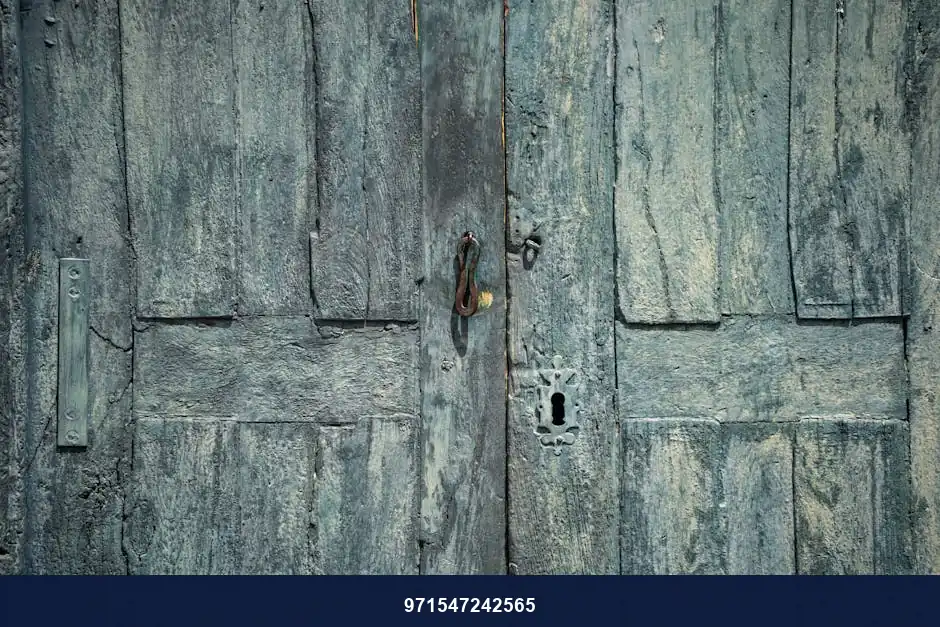 A vintage turquoise wooden door with rustic textures and an antique lock, showcasing colonial architectural style.