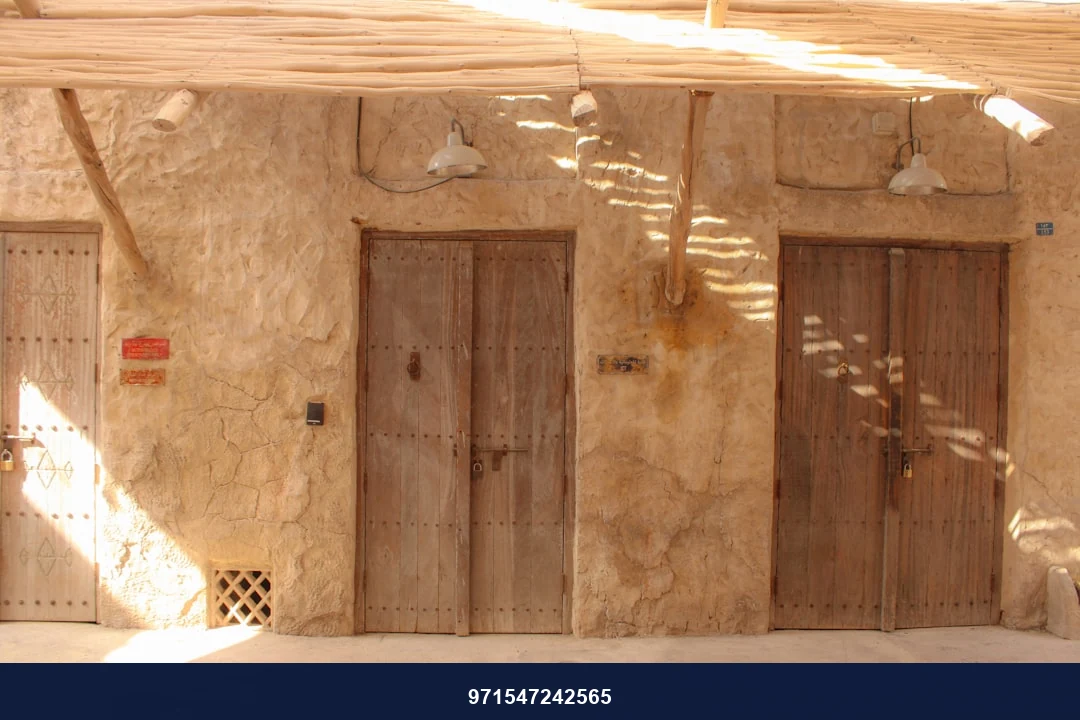 Three weathered wooden doors on a stone wall.