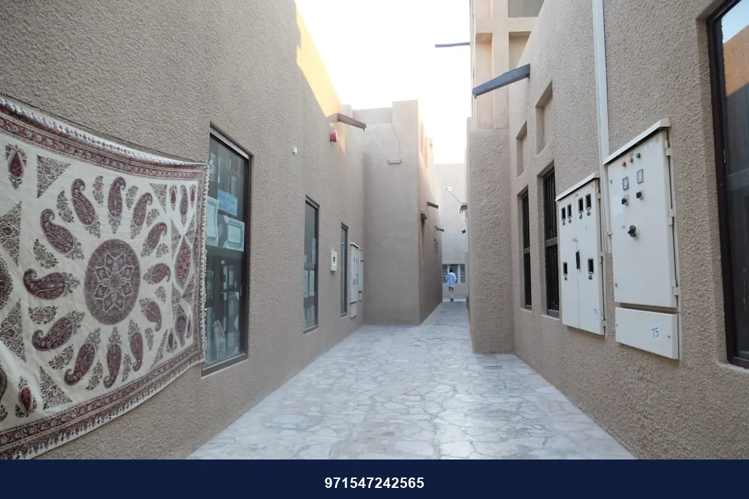 a narrow alley way with a mosaic tile design on the wall