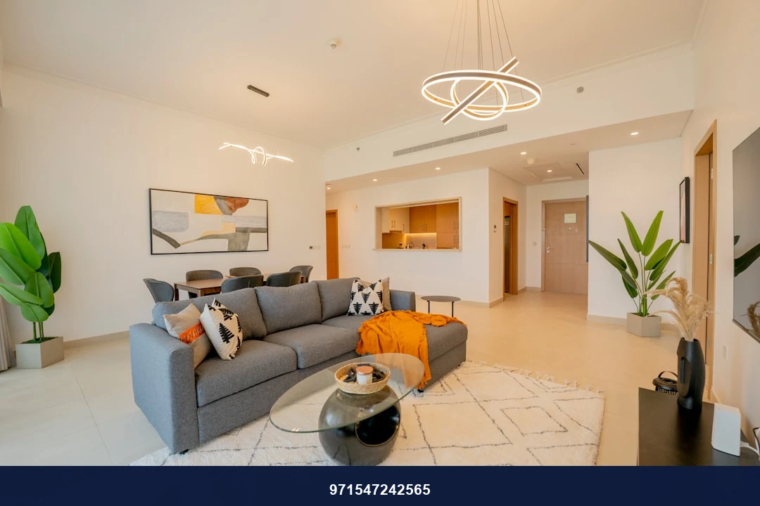 a living room with a gray couch and a white rug