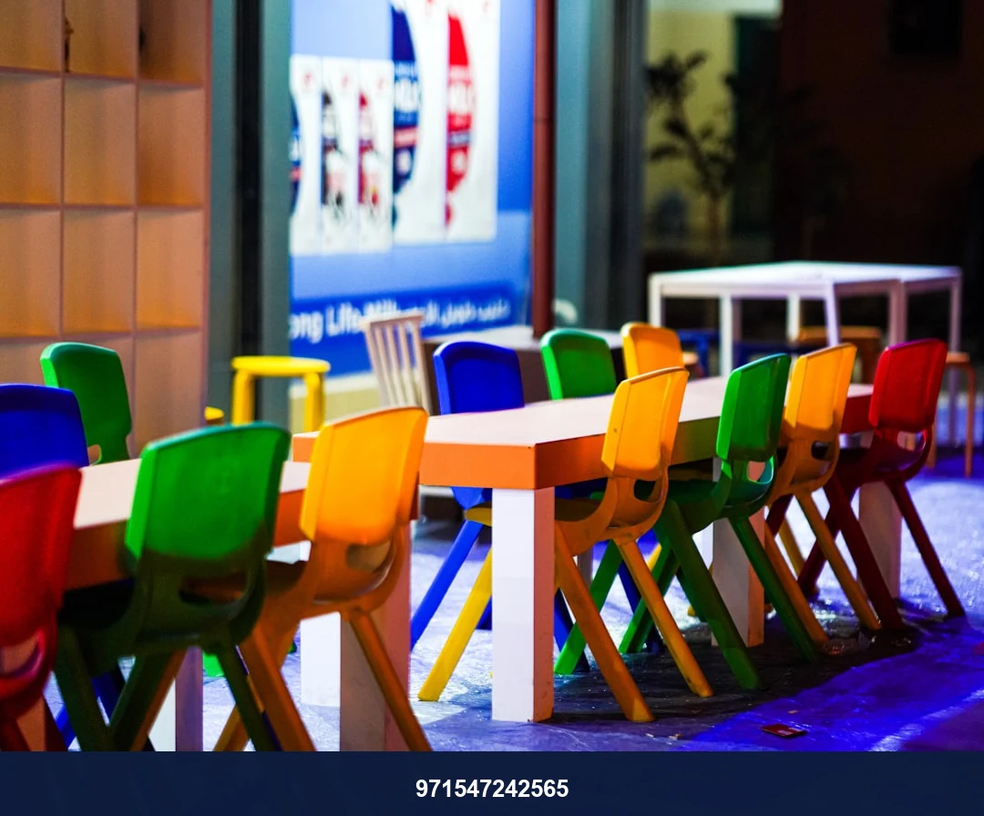 Colorful chairs and tables outside a building.